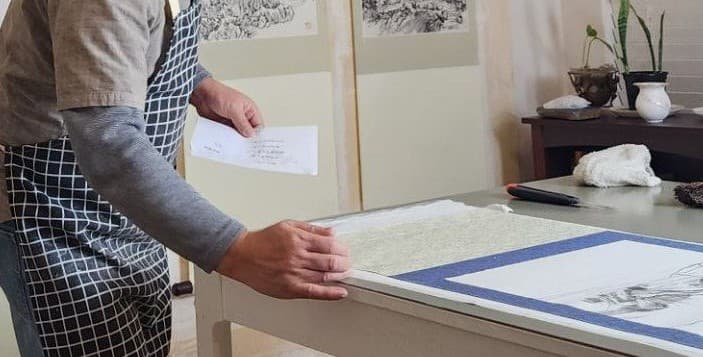 Craftsman working on a traditional East Asian painting